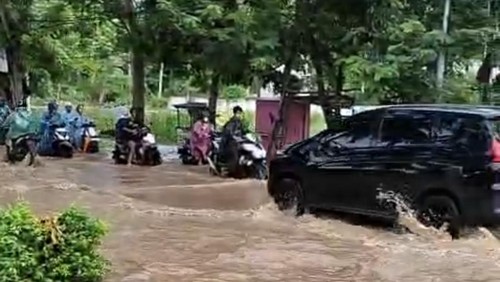 Jalan Raya Senggigi terendam banjir setinggi lutut akibat luapan air dari selokan, Kamis (27/11/2025).