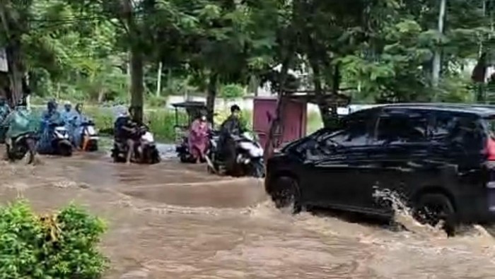 Jalan Raya Senggigi terendam banjir setinggi lutut akibat luapan air dari selokan, Kamis (27/11/2025).