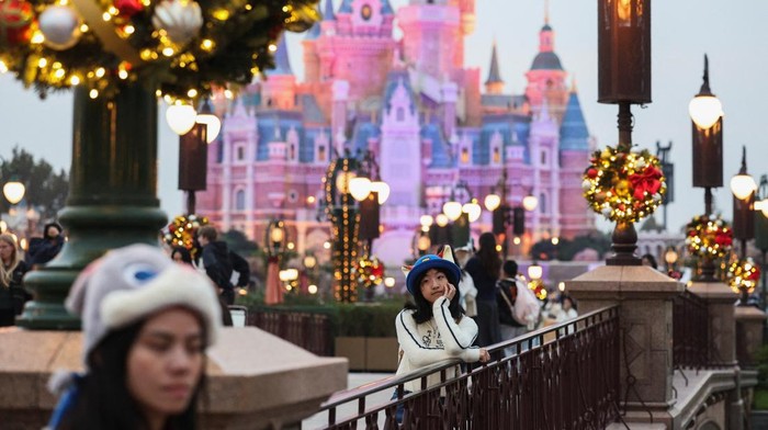 Park visitors take photos of the giant Christmas tree at Shanghai Disneyland in Shanghai, China, November 24, 2025.  REUTERS/Go Nakamura