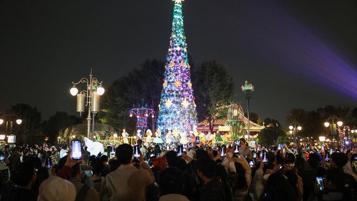 Park visitors take photos of the giant Christmas tree at Shanghai Disneyland in Shanghai, China, November 24, 2025.  REUTERS/Go Nakamura