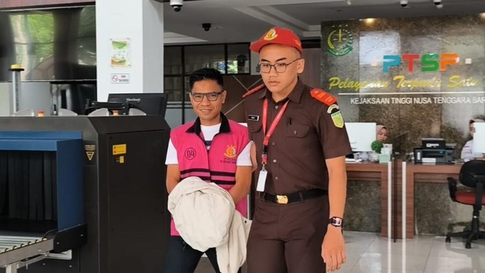 Ketua Komisi IV DPRD NTB, Hamdan Kasim, digelandang menuju mobil tahanan seusai diperiksa sebagai tersangka gratifikasi ‘uang siluman’ di Kejati NTB, Kamis (27/11/2025). (Foto: Abdurrasyid Efendi/detikBali)