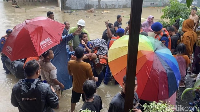 Petugas menggendong nenek Sulasih usai dievakuasi menggunakan perahu karet dari rumahnya di Jalan Abadi Kecamatan Medan Sunggal, Kota Medan. (Mhd Ilham Pradilla/detikSumut).