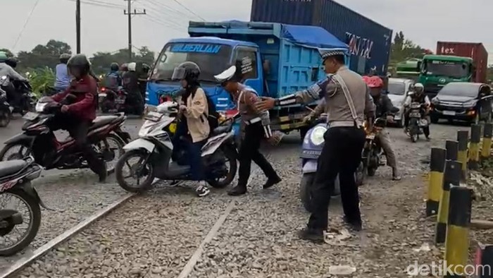 Polisi bantu pengendara di melewati rel Latek Pasuruan yang diperbaiki