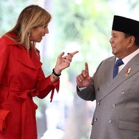 Kali ini ia bersolek dalam balutan coat dress merah. Clutch dan sepatunya pun bewarna sama. (Foto: REUTERS/Willy Kurniawan)