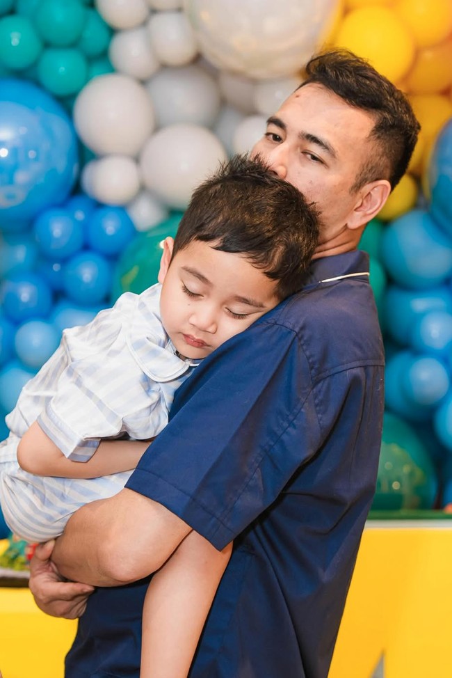 Sedari awal hingga akhir acara, Rayyanza tetap konsisten tertidur pulas. Wajahnya tampak menggemaskan kala tertidur di gendongan sang papa. Foto: Instagram/@raffinagita1717