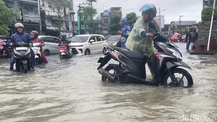 Sejumlah pengendara mendorong dan menaiki sepeda motor mereka yang mogok. (Finta Rahyuni/detikSumut)