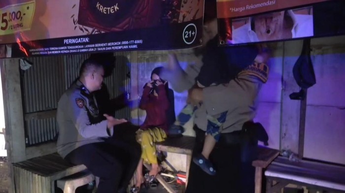 Tangkapan layar seorang wanita menangis dan mengancam akan membuang bayinya yang berusia 2 tahun ke kanal di Kota Makassar.