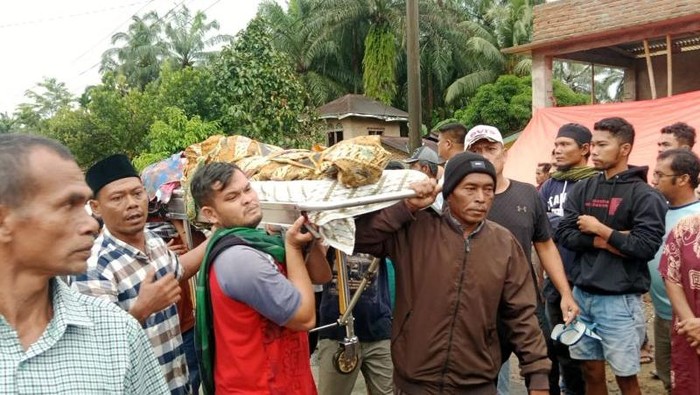 Warga dan pihak keluarga jenazah di Aia Gadang Kecamatan Pasaman Kabupaten Pasaman Barat saat gotong jenazah lewati banjir Sungai Batang Pasaman, Kamis (27/11/2025).