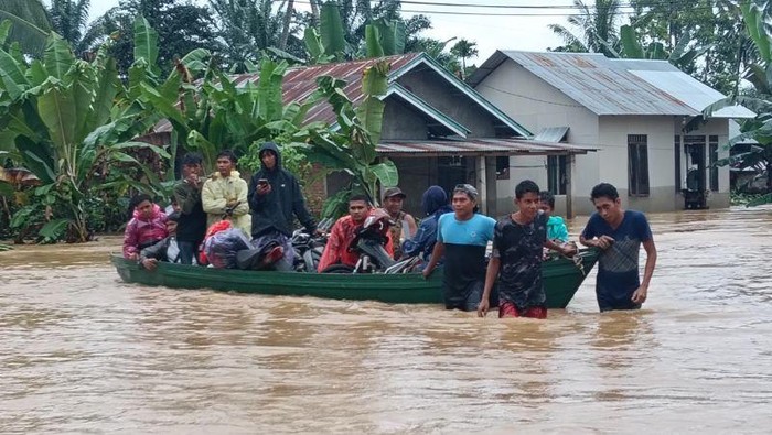 Warga di Aia Gadang Kecamatan Pasaman, Kabupaten Pasaman Barat, Sumatera Barat dievakuasi memakai sampan dan perahu karet mengarungi luapan banjir Sungai Batang Pasaman, Kamis (27/11/2025). (ANTARA/Altas Maulana)