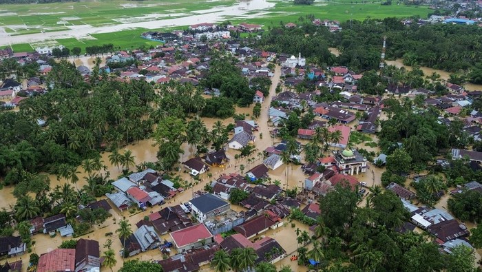 Warga melintasi banjir di Kabupaten Solok, Sumatera Barat, Kamis (27/11/2025). Hujan deras yang melanda daerah tersebut selama tiga hari menyebabkan Sungai Batang Lembang dan Sungai Batang Gawan meluap sehingga menyebabkan 598 kepala keluarga atau sebanyak 3.362 jiwa terdampak, serta 224 rumah terendam. ANTARA FOTO/Wawan Kurniawan/Lmo/rwa.