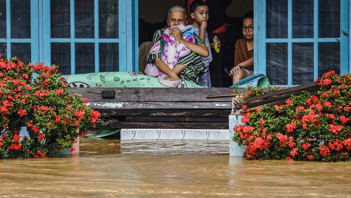 Warga melintasi banjir di Kabupaten Solok, Sumatera Barat, Kamis (27/11/2025). Hujan deras yang melanda daerah tersebut selama tiga hari menyebabkan Sungai Batang Lembang dan Sungai Batang Gawan meluap sehingga menyebabkan 598 kepala keluarga atau sebanyak 3.362 jiwa terdampak, serta 224 rumah terendam. ANTARA FOTO/Wawan Kurniawan/Lmo/rwa.
