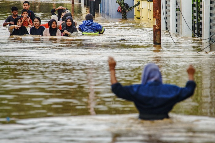 Warga melintasi banjir di Kabupaten Solok, Sumatera Barat, Kamis (27/11/2025). Hujan deras yang melanda daerah tersebut selama tiga hari menyebabkan Sungai Batang Lembang dan Sungai Batang Gawan meluap sehingga menyebabkan 598 kepala keluarga atau sebanyak 3.362 jiwa terdampak, serta 224 rumah terendam. ANTARA FOTO/Wawan Kurniawan/Lmo/rwa.