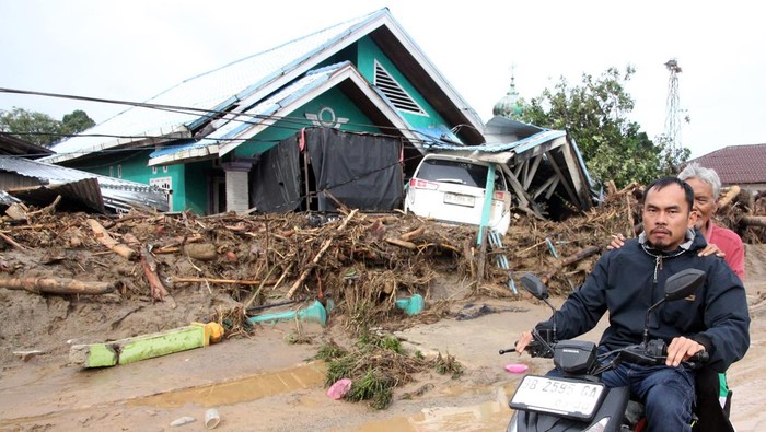 Warga melintas di area rumah yang rusak akibat banjir bandang di Kecamatan Batang Toru, Kabupaten Tapanuli Selatan, Sumatera Utara, Jumat (28/11/2025). BPBD Tapanuli Selatan mencatat hingga Jumat (28/11/2025) sebayak 32 orang meninggal dunia diwilayahnya akibat banjir bandang pada Selasa (25/11/2025). ANTARA FOTO/Yudi Manar/sgd