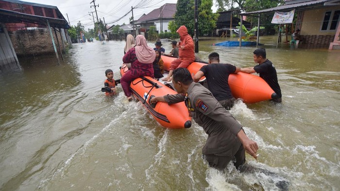 Petugas SAR gabungan mengevakuasi warga yang terdampak banjir di Parak Jambu, Dadok Tunggul Hitam, Padang, Sumatera Barat, Selasa (25/11/2025). Intensitas curah hujan tinggi membuat sejumlah sungai besar di kota itu meluap dan merendam ratusan rumah. ANTARA FOTO/Iggoy el Fitra/sgd