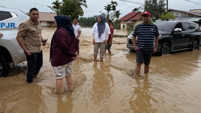 Foto: Ketua Tim Penggerak PKK Aceh Marlina Muzakir (kaos putih) terjebak banjir. (Foto: Abdul Hadi)