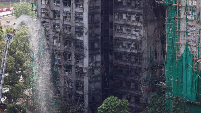 A firefighter works in front of the multiple charred buildings of Wang Fuk Court complex following a deadly fire, in Tai Po, Hong Kong, China, November 28, 2025. REUTERS/Tyrone Siu housing estate,