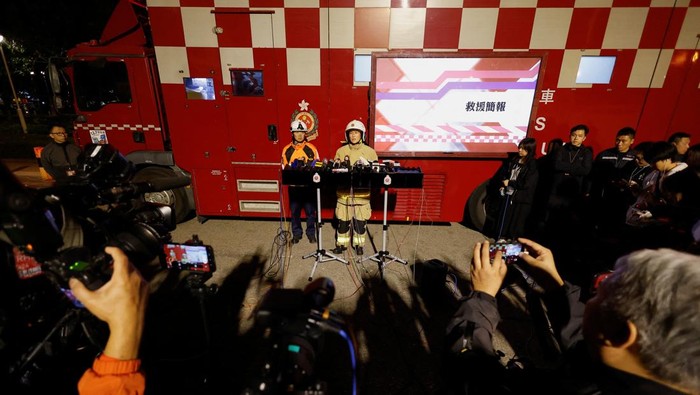 A man walks near the scene of a deadly fire, which broke out yesterday at Wang Fuk Court housing complex, as efforts to extinguish it continue, in Hong Kong, China November 27, 2025. REUTERS/Maxim Shemetov     TPX IMAGES OF THE DAY