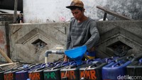 Pedagang air bersih mengisi jeriken yang akan didistribusikan ke permukiman Muara Angke. Air dijual Rp3.000 per jeriken, harga yang dinilai warga paling terjangkau.