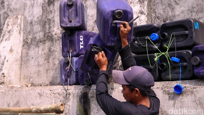 Pedagang air bersih mengisi jeriken yang akan didistribusikan ke permukiman Muara Angke, Jakarta, Jumat (28/11/2025). Mereka menjadi sumber utama air layak konsumsi bagi warga pesisir.