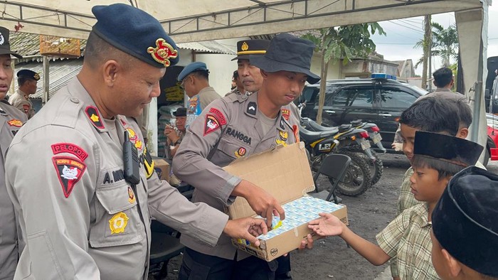 Personel Brimob Polda Jawa Timur (Jatim) bersama Polres Lumajang  membagikan snack dan susu