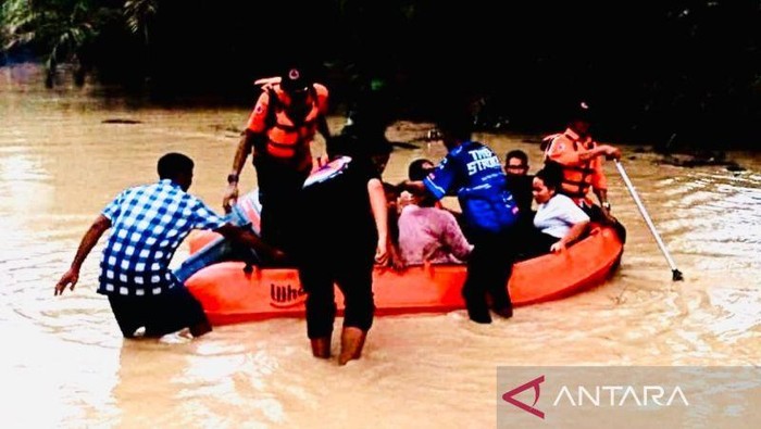 Petugas BPBD Nagan Raya, Aceh, mengevakuasi korban banjir menggunakan perahu karet di kawasan Desa Ujung Lamie, Kecamatan Darul Makmur, Kabupaten Nagan Raya.