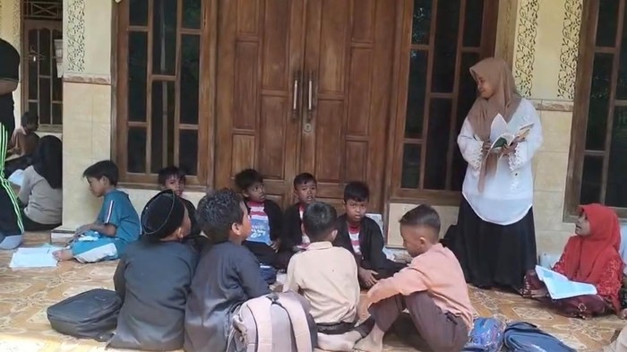 Ratusan siswa salah satu SD Negeri di Bangkalan terpaksa belajar di teras rumah warga gegara salah satu ruangan kelas di sekolah mereka ambruk.