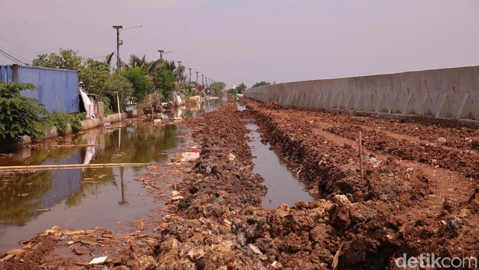 Sejumlah pekerja terlihat membangun taman di kawasan tanggul Pelabuhan Muara Baru pada Jumat (28/11/2025).