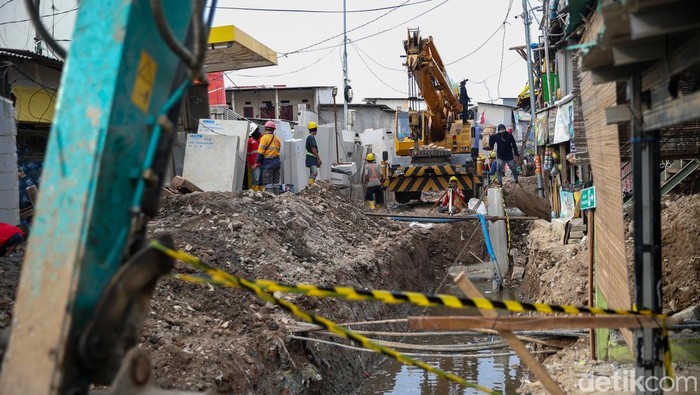 Pekerja dan warga membangun tanggul mitigasi baru di Kampung Nelayan, Muara Angke, Jumat (28/11/2025). Pembangunan ini telah berlangsung dua bulan untuk menahan banjir rob yang rutin melanda kawasan pesisir.