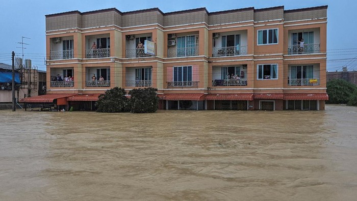 Stranded people look on from their townhomes which are partially submerged in a flooded area in Hat Yai district, which has been affected by heavy rainfall that has hit 10 provinces in southern Thailand and killed several people, in Songkhla province, Thailand, November 24, 2025. REUTERS/Sithichai Chootochana