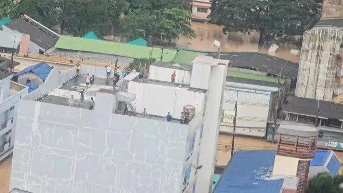 People gather on a rooftop, as seen from a Thai navy helicopter conducting a relief operation in a flooded location given as Hat Yai, Songkhla province, Thailand, affected by heavy rainfall which has impacted several provinces in southern Thailand and has killed several people, in this still image from a video released November 26, 2025. Royal Thai Navy/Handout via REUTERS THIS IMAGE HAS BEEN SUPPLIED BY A THIRD PARTY. NO RESALES. NO ARCHIVES. MANDATORY CREDIT VERIFICATION: Reuters was not able to independently verify the location or the date when the footage was filmed.