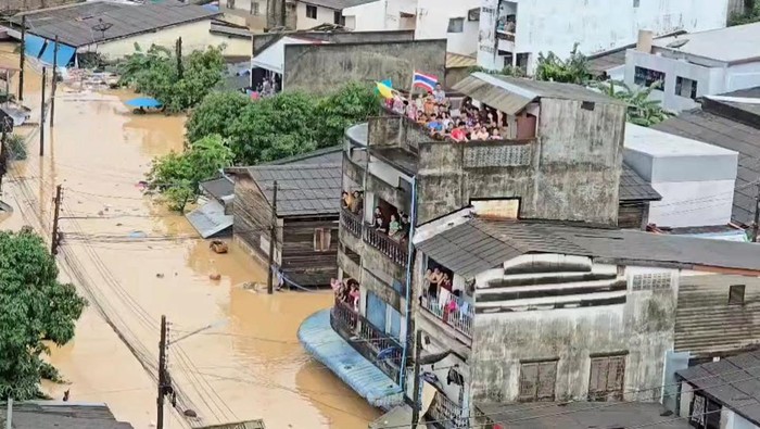 People gather on a rooftop, as seen from a Thai navy helicopter conducting a relief operation in a flooded location given as Hat Yai, Songkhla province, Thailand, affected by heavy rainfall which has impacted several provinces in southern Thailand and has killed several people, in this still image from a video released November 26, 2025. Royal Thai Navy/Handout via REUTERS THIS IMAGE HAS BEEN SUPPLIED BY A THIRD PARTY. NO RESALES. NO ARCHIVES. MANDATORY CREDIT  VERIFICATION: Reuters was not able to independently verify the location or the date when the footage was filmed.