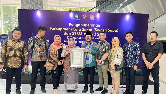 Wawako Palembang dan Kadis Kesehatan memegang penghargaan Swasti Saba Padapa Award 2025