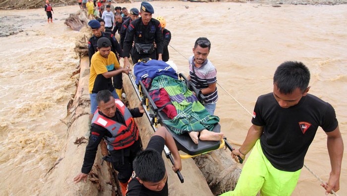 Warga berjalan melintasi sungai dengan jembatan darurat di Desa Aek Garoga, Kecamatan Batang Toru, Kabupaten Tapanuli Selatan, Sumatera Utara, Sabtu (29/11/2025).  Warga terpaksa melintasi jembatan darurat dari batang kayu akibat jalan dan jembatan penghubung antara Kabupaten Tapanuli Selatan menuju Tapanuli Tengah-Sibolga serta Medan putus diterjang banjir bandang pada Selasa (29/11).ANTARA FOTO/Yudi Manar/bar