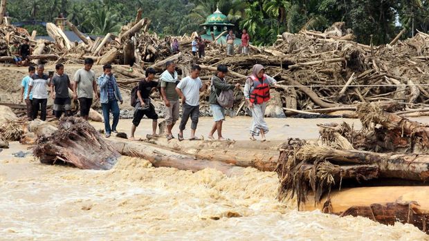 Akses jalan di Tapanuli Selatan putus akibat banjir bandang Warga berjalan melintasi sungai dengan jembatan darurat di Desa Aek Garoga, Kecamatan Batang Toru, Kabupaten Tapanuli Selatan, Sumatera Utara, Sabtu (29/11/2025). Warga terpaksa melintasi jembatan darurat dari batang kayu akibat jalan dan jembatan penghubung antara Kabupaten Tapanuli Selatan menuju Tapanuli Tengah-Sibolga serta Medan putus diterjang banjir bandang pada Selasa (29/11).ANTARA FOTO/Yudi Manar/bar