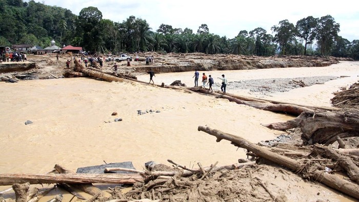 Warga berjalan melintasi sungai dengan jembatan darurat di Desa Aek Garoga, Kecamatan Batang Toru, Kabupaten Tapanuli Selatan, Sumatera Utara, Sabtu (29/11/2025). Warga terpaksa melintasi jembatan darurat dari batang kayu akibat jalan dan jembatan penghubung antara Kabupaten Tapanuli Selatan menuju Tapanuli Tengah-Sibolga serta Medan putus diterjang banjir bandang pada Selasa (29/11).ANTARA FOTO/Yudi Manar/bar