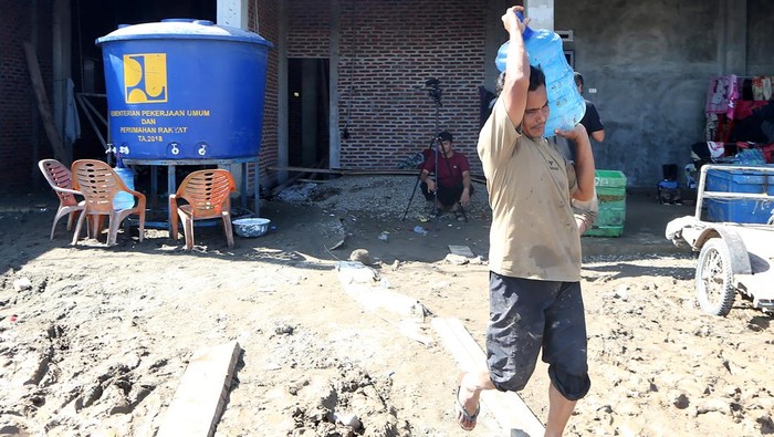 Seorang warga korban bencana banjir membawa galon berisi air bersih yang didistribusikan Kementerian Pekerjaan Umum (PU) di Desa Beuringin, Pidie Jaya, Aceh, Sabtu (29/11/2025). Kementerian PU mengerahkan enam mobil tangki dengan kapasitas 4.000 liter dan 10 tandon berkapasitas 2.000 liter per tandon untuk membantu kebutuhan air bersih di daerah bencana banjir akibat luapan Sungai Meureudu. ANTARA FOTO/Irwansyah Putra