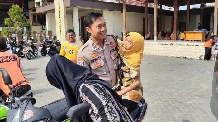 Bhabinkamtibmas di Desa Pandak, Kecamatan Sidoharjo, Sragen, Aipda Siswadi, saat membopong Waginem untuk mengambil BLT.