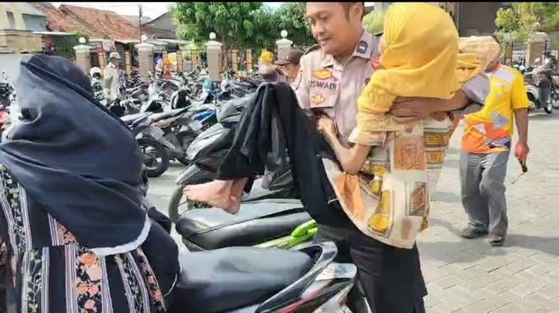 Bhabinkamtibmas di Desa Pandak, Kecamatan Sidoharjo, Sragen, Aipda Siswadi, saat membopong Waginem untuk mengambil BLT.