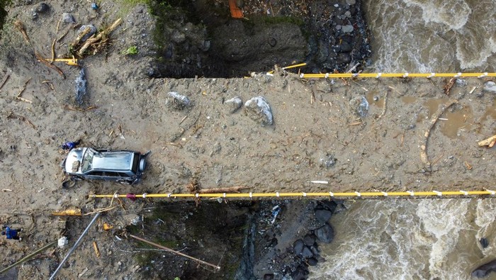 Sebuah mobil tertimbun material longsor di Jembatan Kembar Silaiang, Padang Panjang, Sumbar, Sabtu (29/11/2025). Petugas gabungan masih terus berupaya membersihakan lokasi tersebut dari material lumpur bercampur batang pohon yang menutupi akses jalan Padang-Bukittinggi. ANTARA FOTO/Muhammad Ali/Lmo/tom.