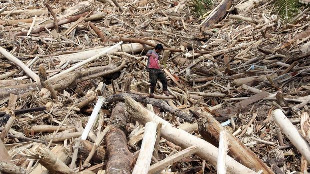 Petugas menggunakan alat berat membersihkan sampah kayu gelondongan pasca banjir bandang di Desa Aek Garoga, Kecamatan Batang Toru, Kabupaten Tapanuli Selatan, Sumatera Utara, Sabtu (29/11/2025). Sampah kayu gelondongan tersebut menumpuk di pemukiman warga dan sungai pasca banjir bandang pada Selasa (25/11). ANTARA FOTO/Yudi Manar