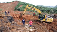 Petugas menggunakan alat berat untuk menyingkirkan puing-puing dan tanah longsor yang menutup akses jalan, sementara keluarga korban menunggu dengan cemas di lokasi.ANTARA FOTO/Yudi Manar