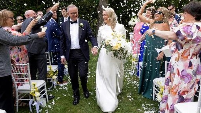 Australias Prime Minister Anthony Albanese (L) and his new wife Jodie Haydon walk together during their wedding ceremony in Canberra on November 29, 2025. (Photo by MIKE BOWERS / AFP) / -- IMAGE RESTRICTED TO EDITORIAL USE - STRICTLY NO COMMERCIAL USE --