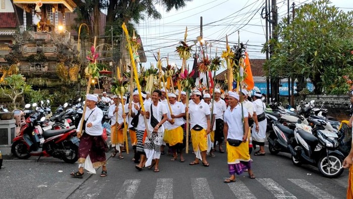 Ratusan pria bertombak berkeliling desa sambil bersorak-sorai dan diiringi baleganjur dalam ritual Ngerebeg Matiti Suara di Desa Adat Blahkiuh, Kecamatan Abiansemal, Badung, Minggu (30/11/2025). (Foto: Agus Eka/detikBali)