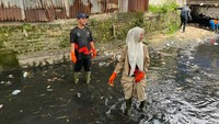 Foto: Walkot Pekanbaru Agung Nugroho dan istri bersihkan sampah di parit turun (Dok Diskominfotik Pekanbaru)