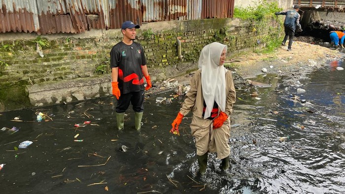 Walkot Pekanbaru Agung Nugroho dan istri bersihkan sampah di parit turun (Dok Diskominfotik Pekanbaru)