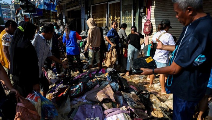 Pasar-pasar di distrik Hat Yai, Provinsi Songkhla, Thailand, kembali dipadati warga pada Minggu (30/11/2025), bukan untuk mencari barang baru, melainkan berburu produk yang rusak akibat banjir bandang mematikan yang melanda kawasan tersebut. Sejumlah warga terlihat menyusuri lorong pertokoan yang masih basah, memilih barang-barang yang jalannya terendam air namun masih dianggap layak pakai. REUTERS/Athit Perawongmetha