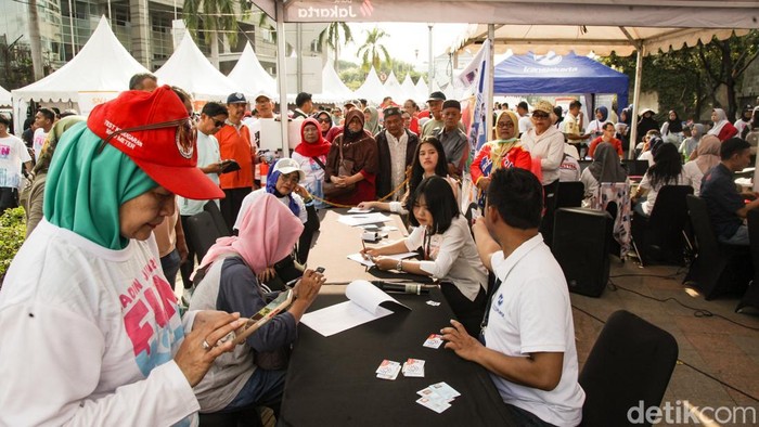 Warga ramai-ramai mengambil kartu Jakarta Mobilitas Bebas Akses (JakMob). Kartu ini dapat digunakan untuk naik transportasi umum gratis di Jakarta.