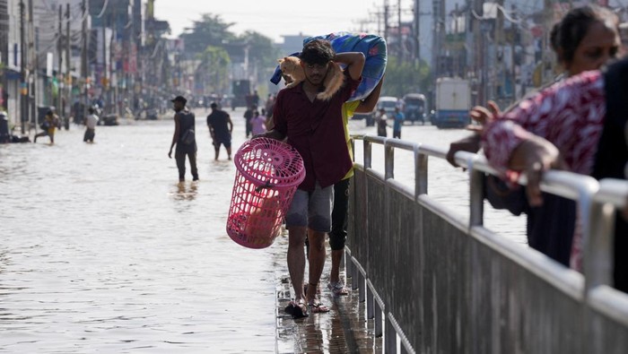 Hujan deras yang mengguyur Sri Lanka sejak Jumat malam menyebabkan sejumlah wilayah di distrik Malwana dan sekitarnya terendam banjir parah. Warga yang tinggal di area rendah terpaksa berkumpul di titik-titik yang masih aman sambil menanti bantuan, sementara aktivitas masyarakat praktis lumpuh total pada Minggu (30/11/2025). REUTERS/Thilina Kaluthotage