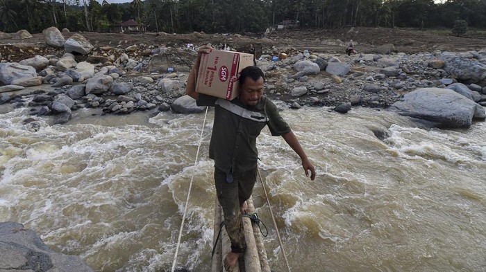 Warga menyeberangi jembatan darurat di atas aliran Sungai Nanggang di Nagari Salareh Aia Timur, Palembayan, Agam, Sumatera Barat, Minggu (30/11/2025). Jembatan darurat dari pohon pinang yang menghubungkan Jorong Pasa menuju Jorong Subarang Aia di Nagari Salareh Aia Timur itu menjadi satu-satunya akses warga untuk mendapatkan bantuan pascaterputusnya akses jembatan akibat banjir bandang yang terjadi pada Kamis (27/11). ANTARA FOTO/Wahdi Septiawan/nz.