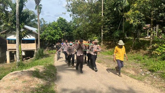 Brimob Polda Riau mengevakuasi jenazah ibu dan anak korban banjir di Agam, Sumbar, Senin (1/12/2025).